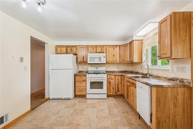 kitchen featuring white appliances, a sink, baseboards, and dark countertops