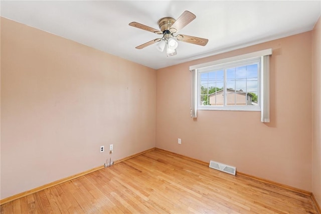 empty room with light wood-style flooring, a ceiling fan, and baseboards