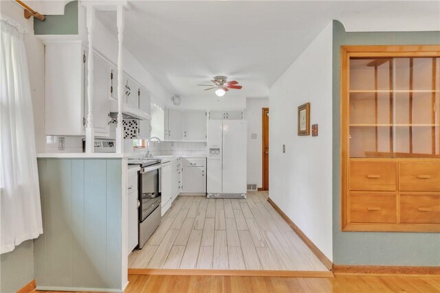 kitchen featuring white refrigerator with ice dispenser, range with electric stovetop, ceiling fan, and light wood-style flooring
