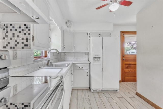 kitchen with white refrigerator with ice dispenser, a sink, electric range, under cabinet range hood, and a ceiling fan