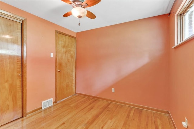 unfurnished bedroom featuring wood finished floors, baseboards, and a ceiling fan