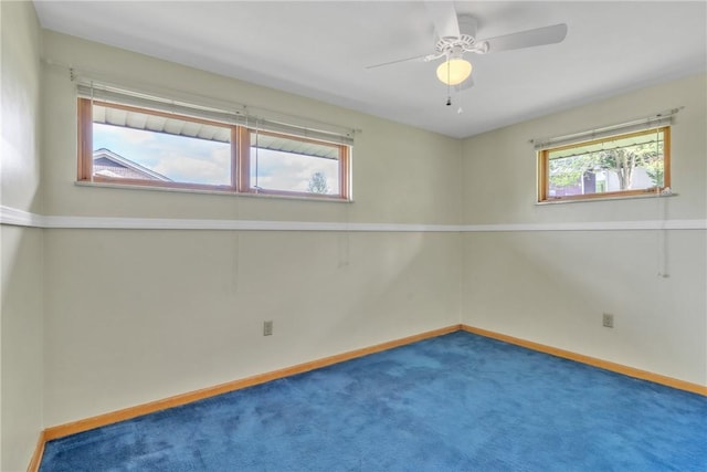 carpeted spare room featuring healthy amount of natural light, baseboards, and ceiling fan