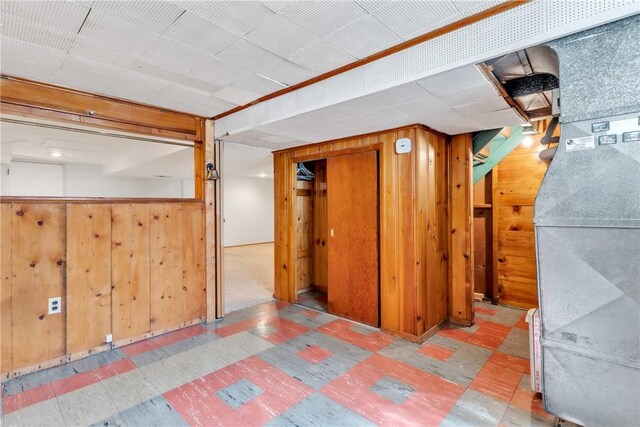 finished below grade area featuring wooden walls and tile patterned floors