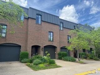 view of building exterior with concrete driveway and an attached garage