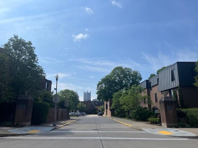 view of concrete road with curbs, sidewalks, street lights, and traffic signs