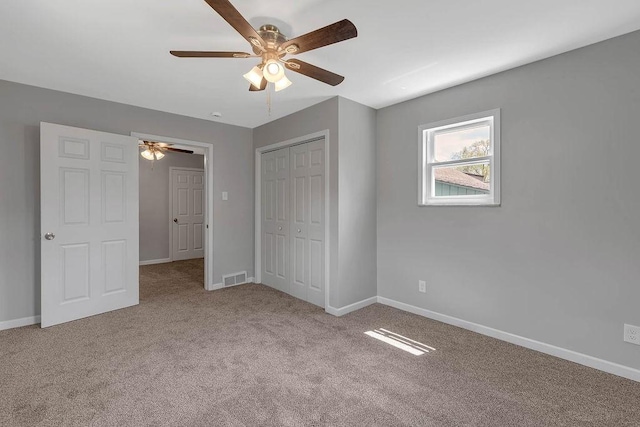 unfurnished bedroom with carpet floors, baseboards, a closet, and ceiling fan