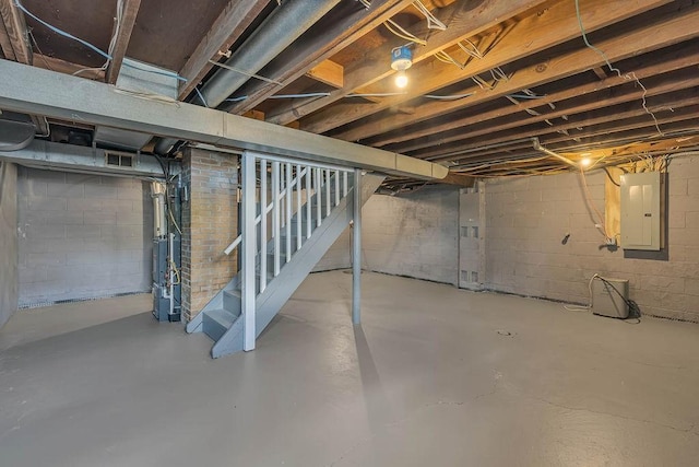unfinished basement featuring electric panel and stairway
