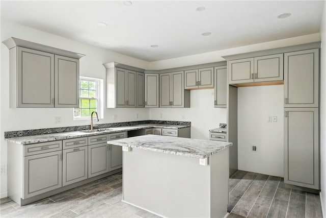 958 Cliff Mine Rd, Coraopolis, PA 15108 - kitchen with gray cabinets, a sink, wood tiled floors, a kitchen island, and light stone counters