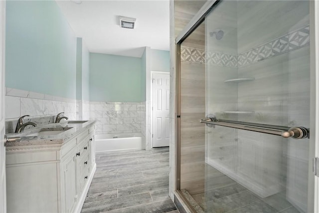 958 Cliff Mine Rd, Coraopolis, PA 15108 - bathroom featuring tile walls, a shower stall, a garden tub, a wainscoted wall, and double vanity