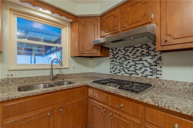 121 Pilgrim Dr, Leet Twp, PA 15143 - kitchen with under cabinet range hood, stainless steel gas stovetop, a sink, brown cabinets, and decorative backsplash
