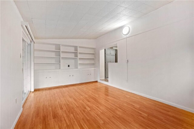 412 Palomino Dr, North Fayette, PA 15071 - unfurnished living room featuring light wood-style floors, baseboards, built in features, and lofted ceiling