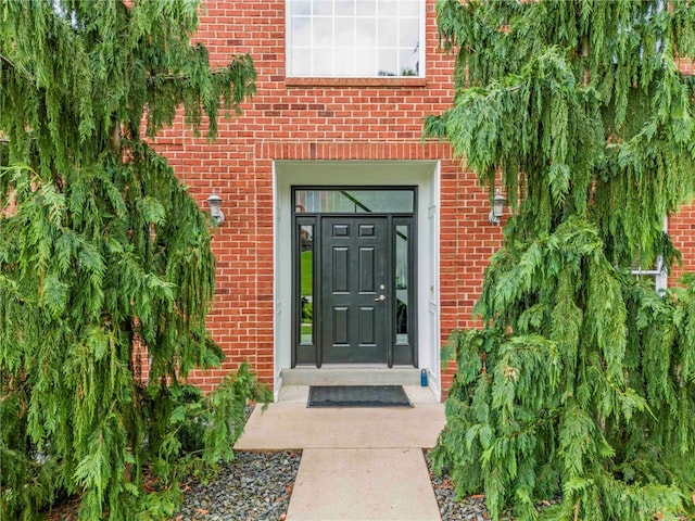 view of exterior entry featuring brick siding