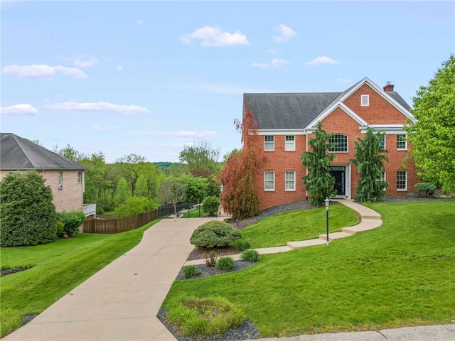 view of front of property featuring brick siding, driveway, and a chimney