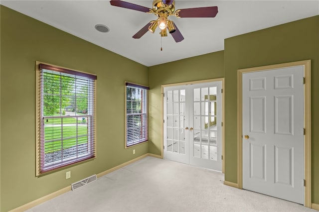 unfurnished bedroom featuring french doors, carpet, baseboards, and a ceiling fan