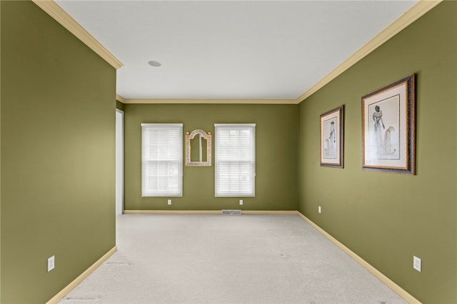 spare room featuring crown molding, baseboards, and carpet