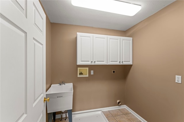 clothes washing area with hookup for an electric dryer, cabinet space, washer hookup, tile patterned flooring, and baseboards