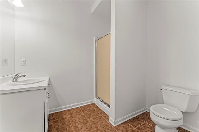 bathroom with toilet, baseboards, vanity, and a stall shower