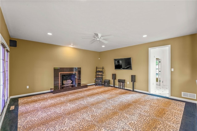 unfurnished living room with carpet floors, baseboards, a fireplace, a ceiling fan, and recessed lighting