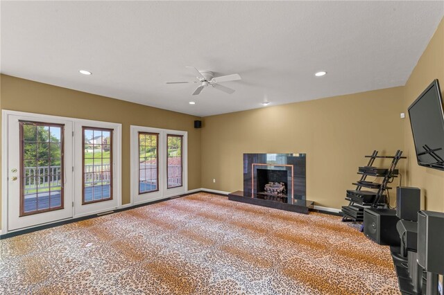 living area with a fireplace with raised hearth, ceiling fan, carpet floors, recessed lighting, and baseboards