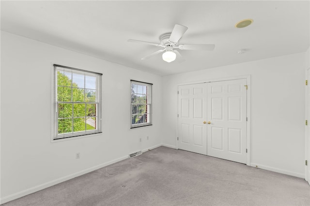 unfurnished bedroom featuring carpet flooring, baseboards, a closet, and ceiling fan