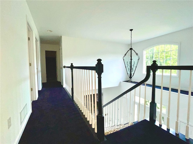 hall with an upstairs landing and a chandelier