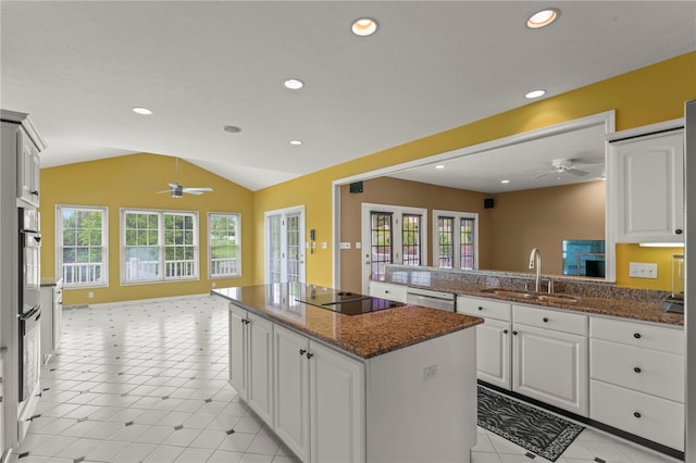 kitchen with a sink, a ceiling fan, black electric cooktop, vaulted ceiling, and dishwasher