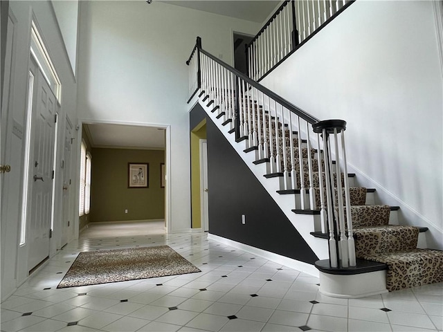 stairs featuring a high ceiling, baseboards, and tile patterned flooring