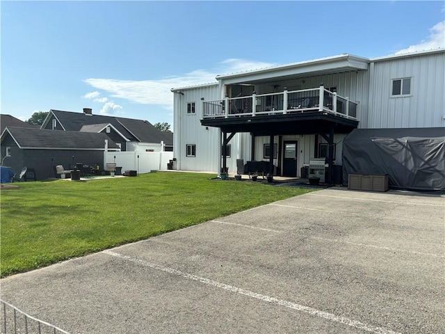 back of property with a deck, a yard, and board and batten siding