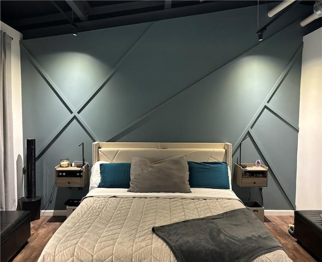 bedroom featuring wood finished floors and baseboards