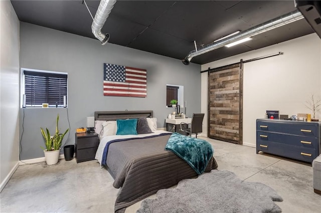 bedroom featuring concrete flooring, a barn door, and baseboards