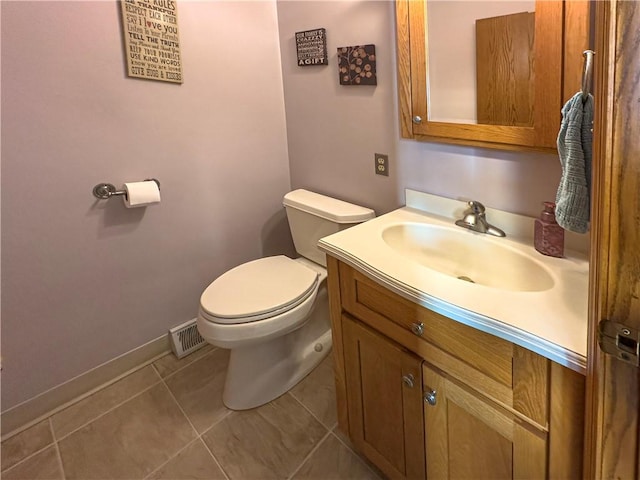 bathroom featuring toilet, vanity, baseboards, and tile patterned floors