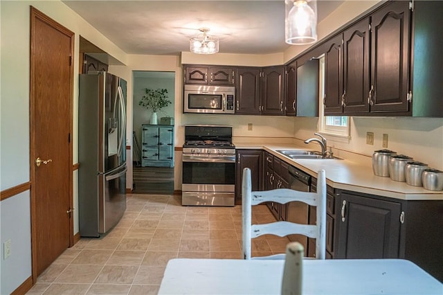 kitchen featuring appliances with stainless steel finishes, a sink, light countertops, dark brown cabinets, and light tile patterned flooring