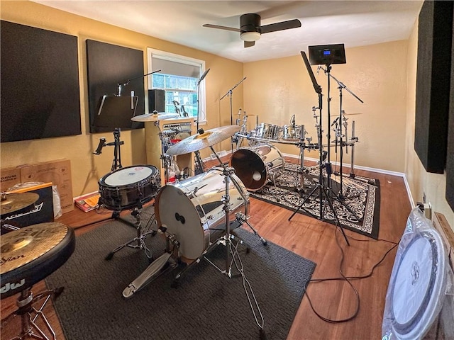 exercise area featuring wood finished floors and ceiling fan