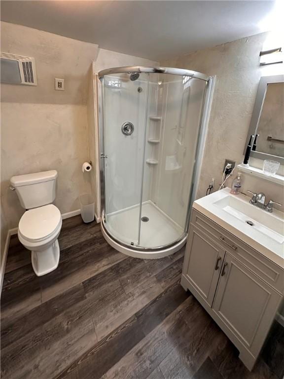 full bath with wood finished floors, a stall shower, toilet, and vanity