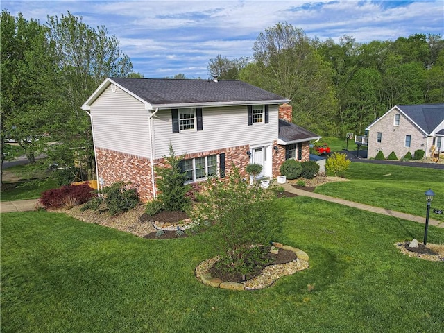 traditional-style house featuring a front lawn and brick siding
