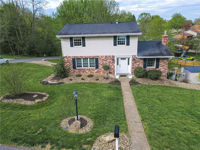 traditional-style home featuring brick siding, a front yard, a chimney, and a shingled roof