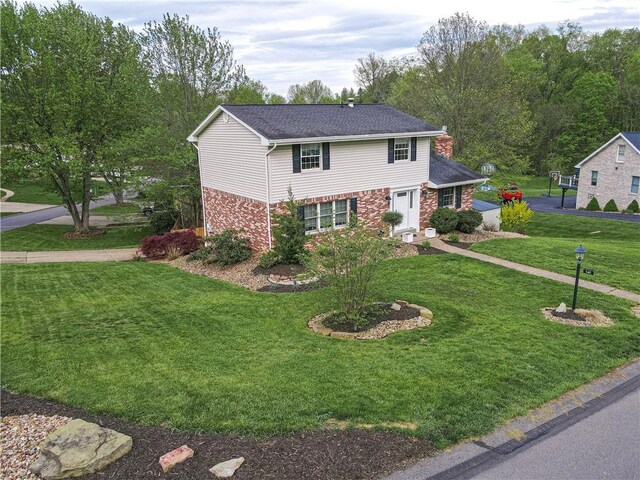 traditional home featuring brick siding, a front lawn, and a shingled roof
