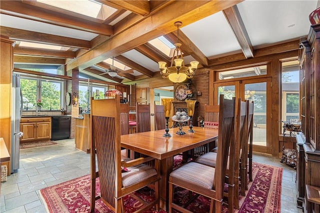 dining room with stone tile floors, french doors, a skylight, wood walls, and ceiling fan