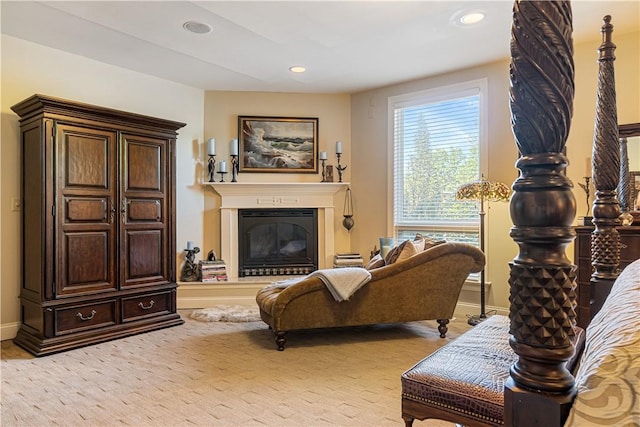 living area with recessed lighting, a glass covered fireplace, and baseboards