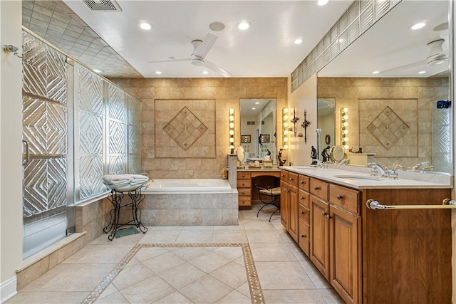 bathroom with ceiling fan, a garden tub, double vanity, tile patterned floors, and tile walls