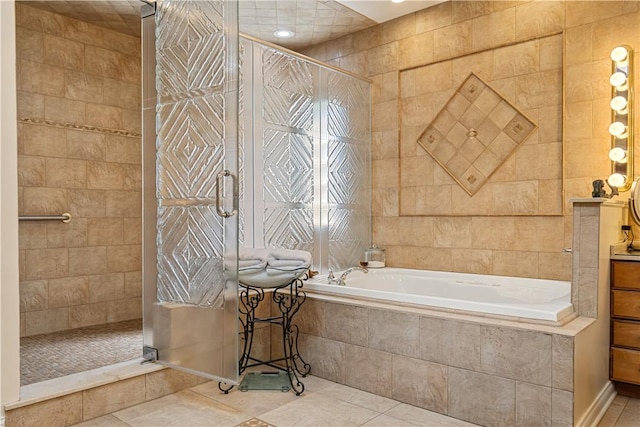 bathroom with a tile shower, a bath, tile patterned floors, vanity, and tile walls