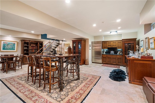 dining space featuring recessed lighting, bar, and stairway