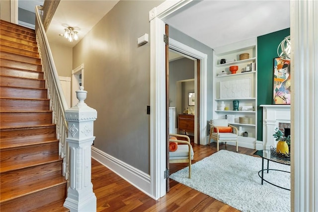 526 Armandale St, Central North Side, PA 15212 - stairs featuring built in shelves, wood finished floors, a fireplace with flush hearth, and baseboards