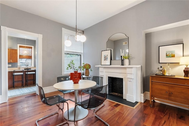 526 Armandale St, Central North Side, PA 15212 - dining area featuring dark wood-style floors, a fireplace, and baseboards