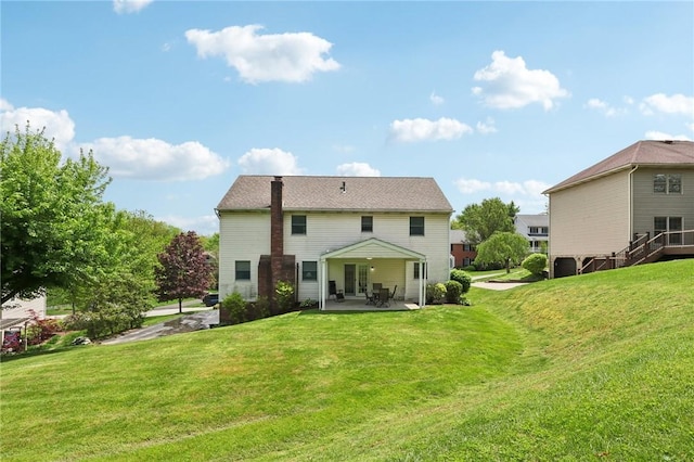 back of house featuring a patio and a yard