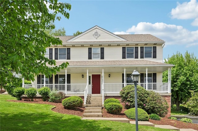 view of front of home featuring a porch, a front yard, and a shingled roof