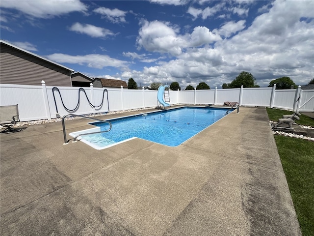view of pool featuring a water slide, a patio, a fenced backyard, and a diving board