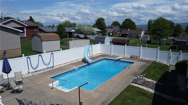 view of swimming pool with a water slide, a patio, a residential view, a storage shed, and an outdoor structure