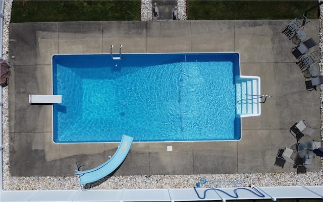 view of swimming pool with a diving board