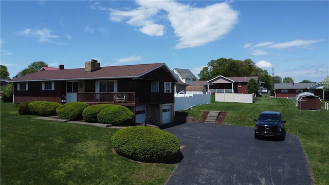 ranch-style home featuring asphalt driveway, an attached garage, and a chimney